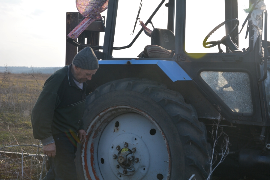 Фермер оглядає трактор, який було пошкоджено внаслідок бойових дій