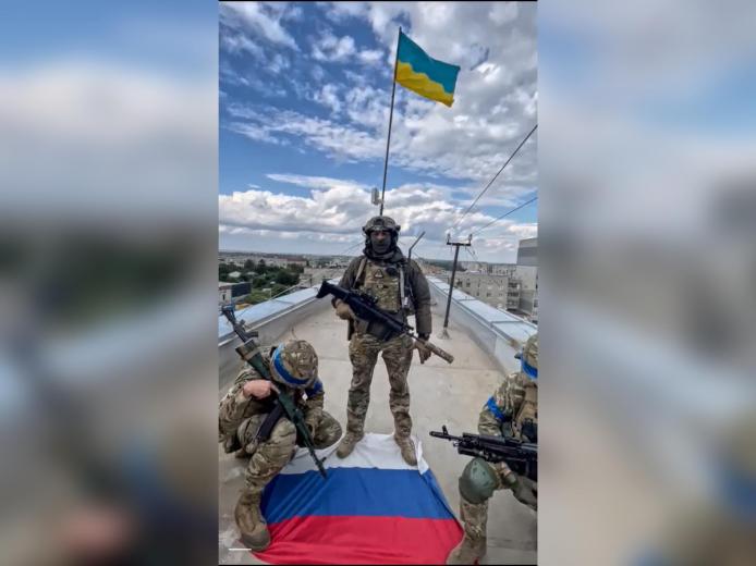 Бійці спецпідрозділу ГУР "Кракен" піднімають український прапор над Балаклією, Харківська область