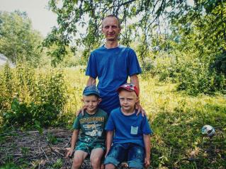 На фото Роман Шаламов із синами та знищене російськими окупантами село Довгеньке